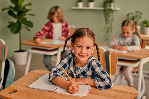 smiling girl at a desk - Precision Educational Diagnostics smiling girl at a desk